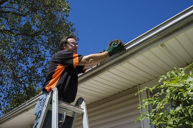 roofing technician replacing a rusted and leaking gutter in Bell Canyon CA